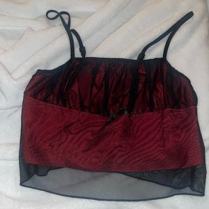 Red cropped cami with black mesh overlay.
